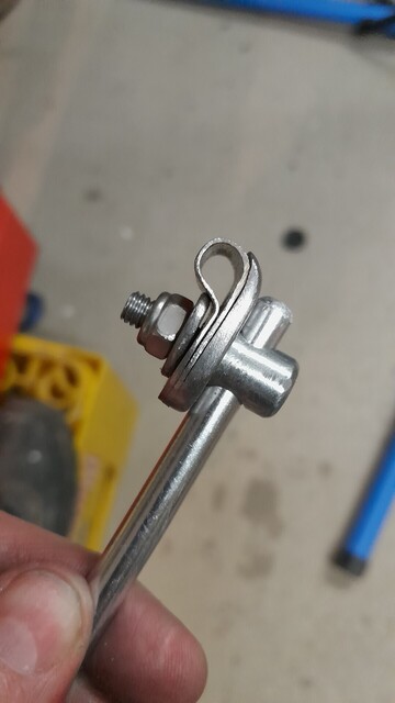 The P clamp with the thick curled part on the outside is now attached to an aluminium rod through the eye of the eyebolt. The P is empty.