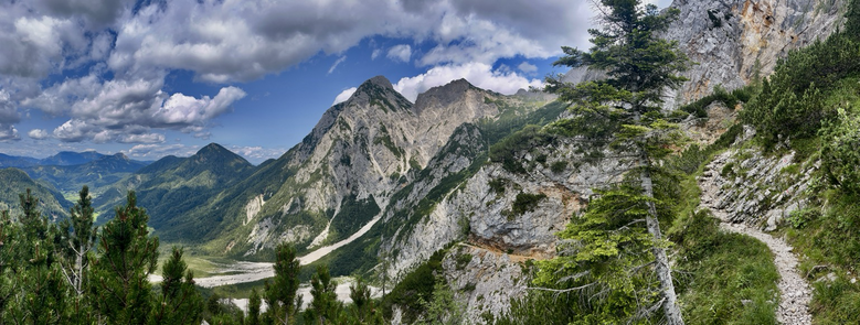 Bergpanorama mit Blick ins Tal links und hohen Bergspitzen rechts 
