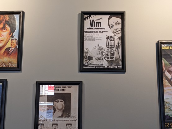 1980 advertisement from India for vim improved perfume on a wall with movie posters and ads from India