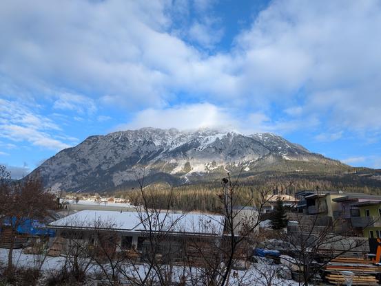 Blue sky, a few white clouds, awesome mountain with a bit of a snow