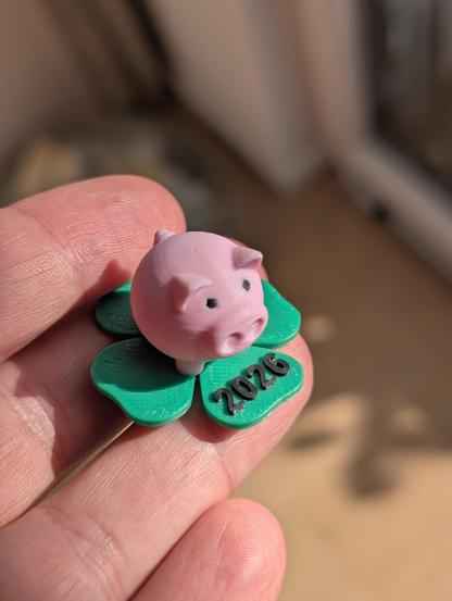 3D printed lucky charm in form of a pig with "2026" printed on the basis which resembles a four-leaf clover