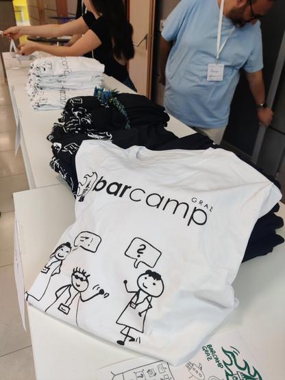 Empfangstisch mit T-Shirts und Leuten, die suck gerade anmelden 