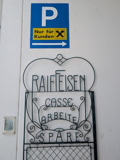 altes Eisentor mit Schriftzug:
Raiffeisen
CASSE
ARBEITE
SPARE
