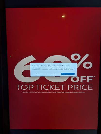 A public signage screen showing a Windows update dialog